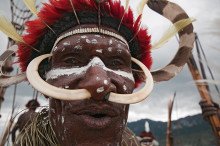Tribesman with traditional feather headdress and pig tusks, Baliem valley, West Papua