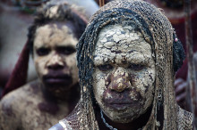 Locall tribeswoman with mud faces and netbags, Baliem valley, West Papua