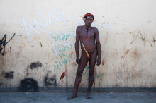 Tribesman with Koteka posing in front of Grafitti painted wall, Wamena, West Papua